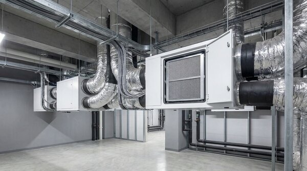 Wall-mounted energy recovery ventilator unit connected to ductwork