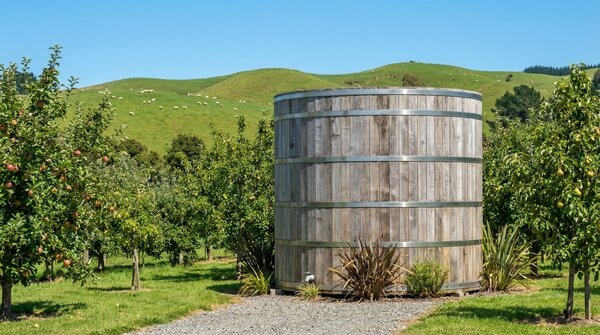 Large timber water storage tank in landscape setting